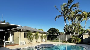 Una piscina con borde de azulejos, rodeada por una terraza pavimentada.