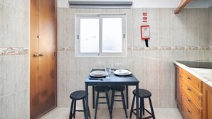 Une cuisine équipée d’une table à manger, de quatre tabourets, d’une fenêtre et d’un panneau d’information sur la sécurité incendie.