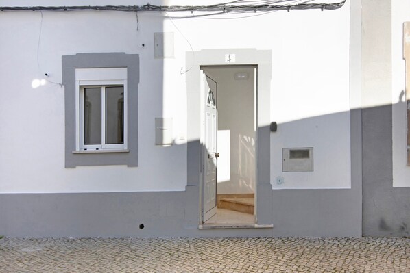 A building with a door marked '4', a window, and a small square window on the wall.