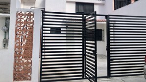 A gated entrance with a decorative metal gate and a white building with a tiled roof. - Depa Lunero, 5 minutes walking from the beach! (Cancún)