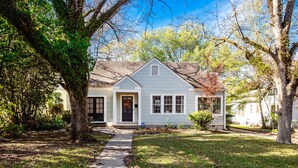 A single-story house with a front porch, a visible garage door, and a pathway leading to the entrance. - NEW! Stylish and Modern Home In the Heart of the Popular Fondren District (Jackson)