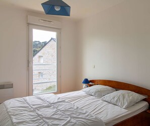 Relax in a serene bedroom with a comfortable bed, large window, and stunning view.