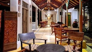A spacious indoor area with wooden furniture and a high ceiling. - Bebek Cottages Sanur (Denpasar)