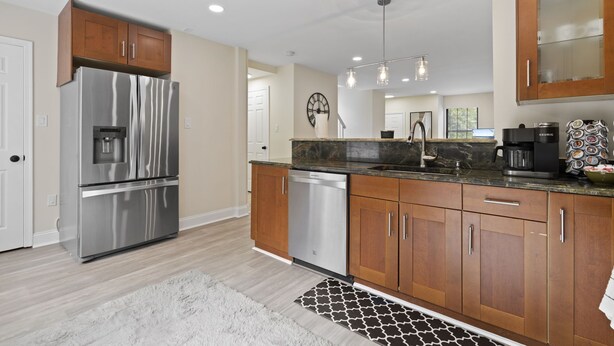 A modern kitchen with stainless steel appliances, wooden cabinets, and a marble countertop. - Premium Modern TH • Near Dulles Airport • 2 Free Parking (Clifton)