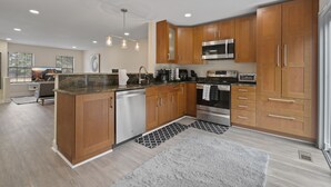 A modern kitchen with wooden cabinets, stainless steel appliances, and a central island. - Premium Modern TH • Near Dulles Airport • 2 Free Parking (Clifton)