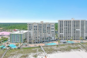 Un hotel de varios pisos con zona de piscina, acceso a la playa y vistas del paisaje circundante.