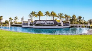 A sign for Lakewood National with a pool and palm trees in the background. - Resort-style 1st Floor Condo in Lakewood National Golf Community-Lakewood Ranch! (Lakewood Ranch)