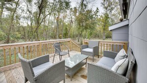 A deck with wicker furniture and a view of trees. - Deck, Yard & Outdoor Dining: Destrehan Getaway! (Destrehan)