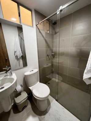 Een douche, handdoeken, zeep, toiletpapier