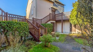 A two-story house with a wooden staircase leading to a balcony.