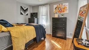 Ein Schlafzimmer mit Bett, Schminktisch und Deckenventilator.
