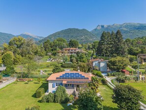 A residential area with houses, a solar panel roof, and a mountainous backdrop. - Giardino del Sole by Interhome (Camaiore)