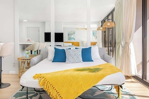 Habitación de hotel moderna con una cama grande, un escritorio y vistas a la ciudad.