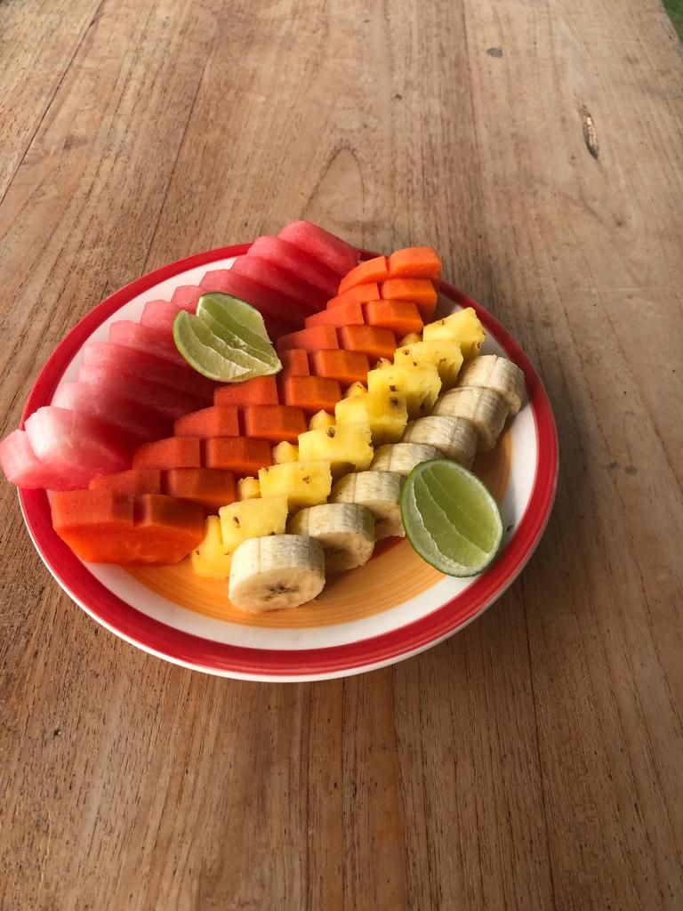 Plat amb talls de fruita sobre una taula de fusta.