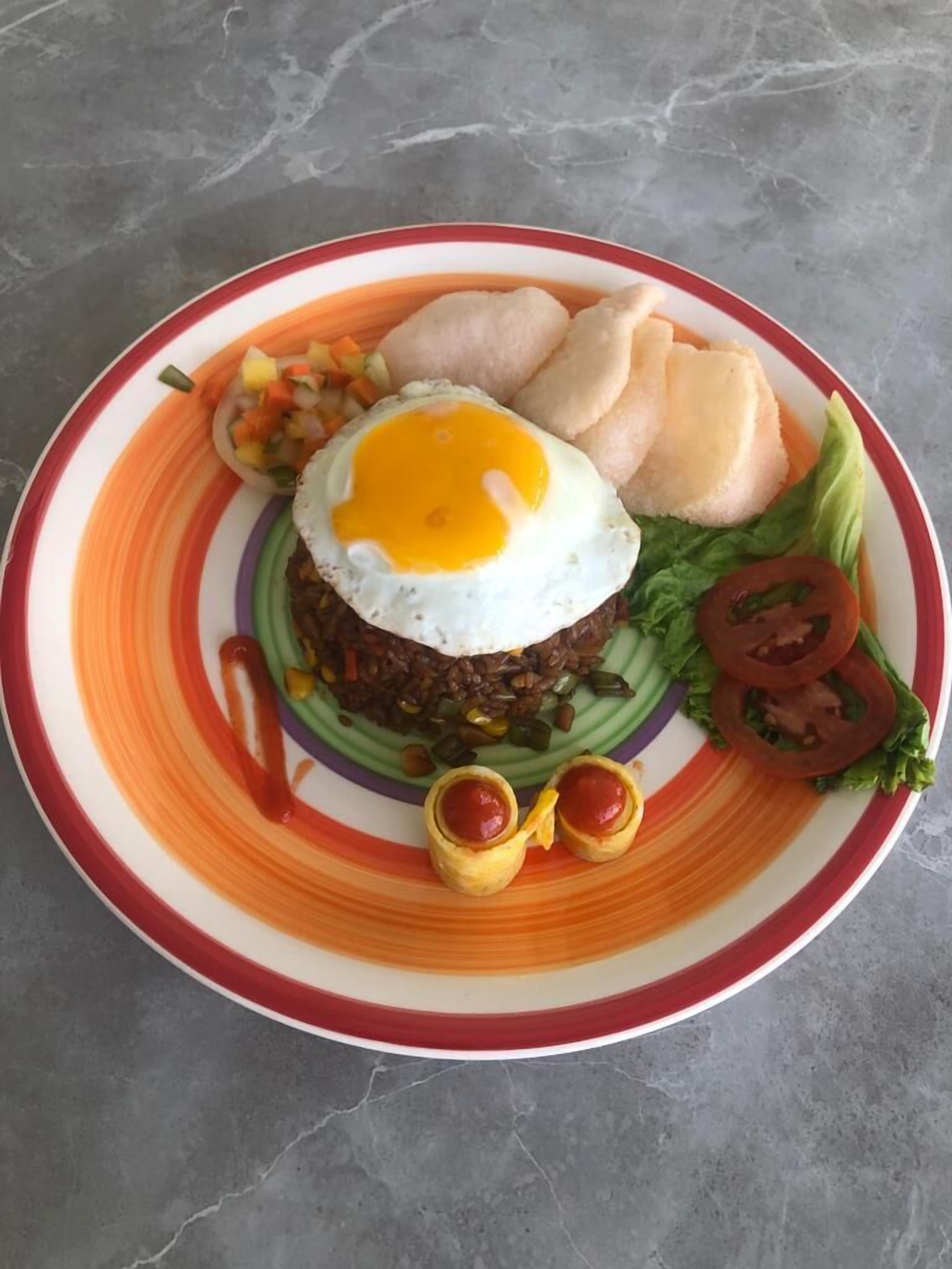 A plate with a fried egg, rice, vegetables, and a slice of bread.