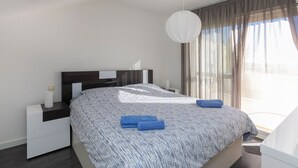 A modern bedroom with a large bed, a bedside table, a nightstand, and a hanging light fixture. - Como siempre by Interhome (Vinarós)