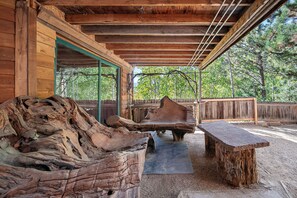 An outdoor wooden structure with a bench and a table made from tree stumps. - Adventures at Angel's Landing await you! Apartment in large mountain home for 3. (Idaho Springs)