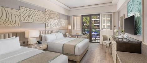 A hotel room with two beds, a desk, a TV, and a balcony with outdoor furniture.