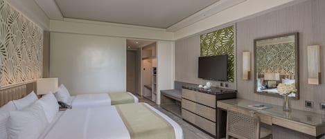 A hotel room with two beds, a desk, a television, and a bathroom visible through an open door.
