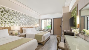 Habitación de hotel con dos camas, un escritorio, una silla, un televisor y una ventana con vistas a zonas verdes.