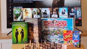 A television displaying 'Leave the World Behind' on Netflix, surrounded by board games like Codenames Duet, Chess, Monopoly, Uno, and Phase 10. - ✨Gazeley Gem | Your Hamilton Hideaway Relax, Explore, Indulge (Hamilton)