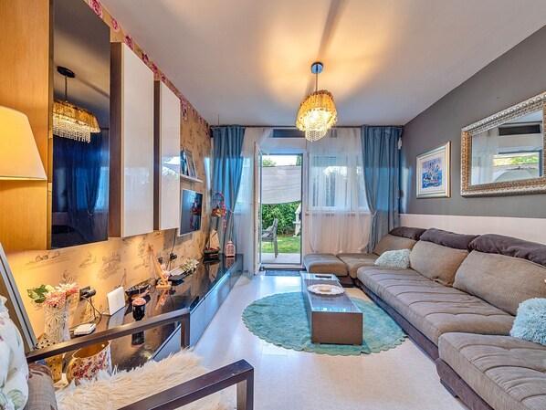 A modern living room with a sofa, a coffee table, and a chandelier.