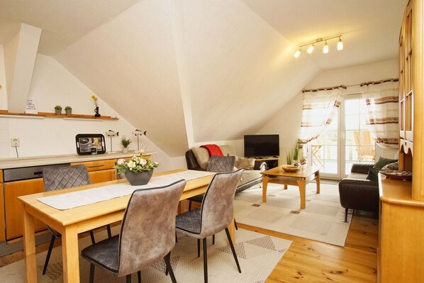 A cozy loft-style apartment with a dining area, kitchen, and living space.