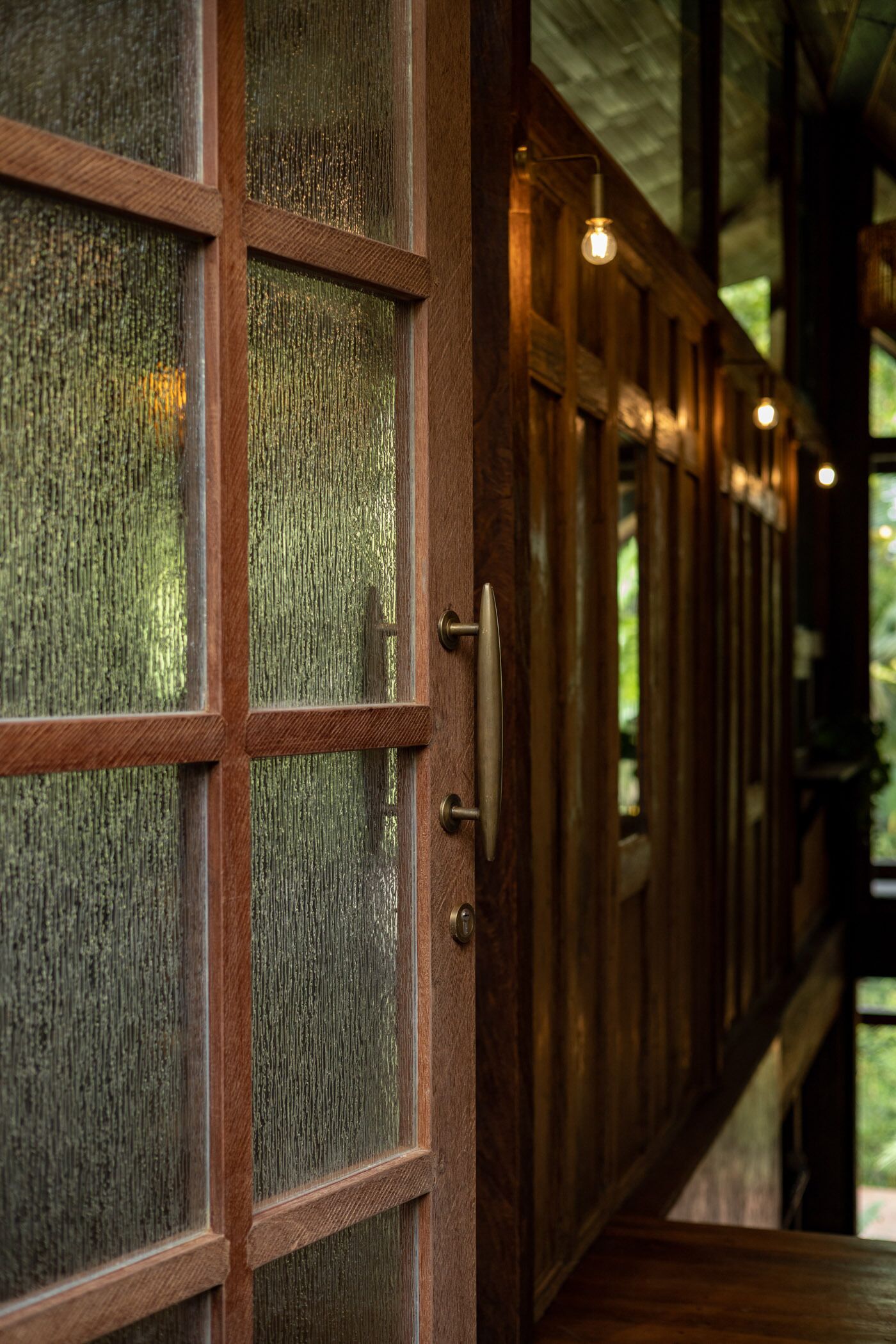 A wooden door with frosted glass panels and a brass handle.