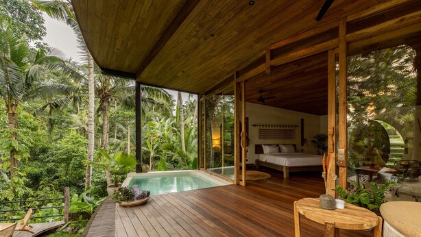A wooden deck with a pool, surrounded by lush greenery. - Casa Pohon Ubud (Ubud)