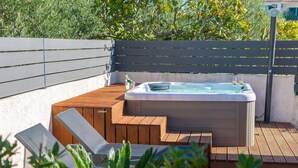 A hot tub on a wooden deck with steps leading up to it, surrounded by greenery. - Bernarda by Interhome (Krk/Kornić)