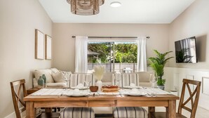 A dining area with a wooden table set for four, surrounded by upholstered chairs. - * When in Naples *Heated Pool Villa, 2mil downtown (Naples)