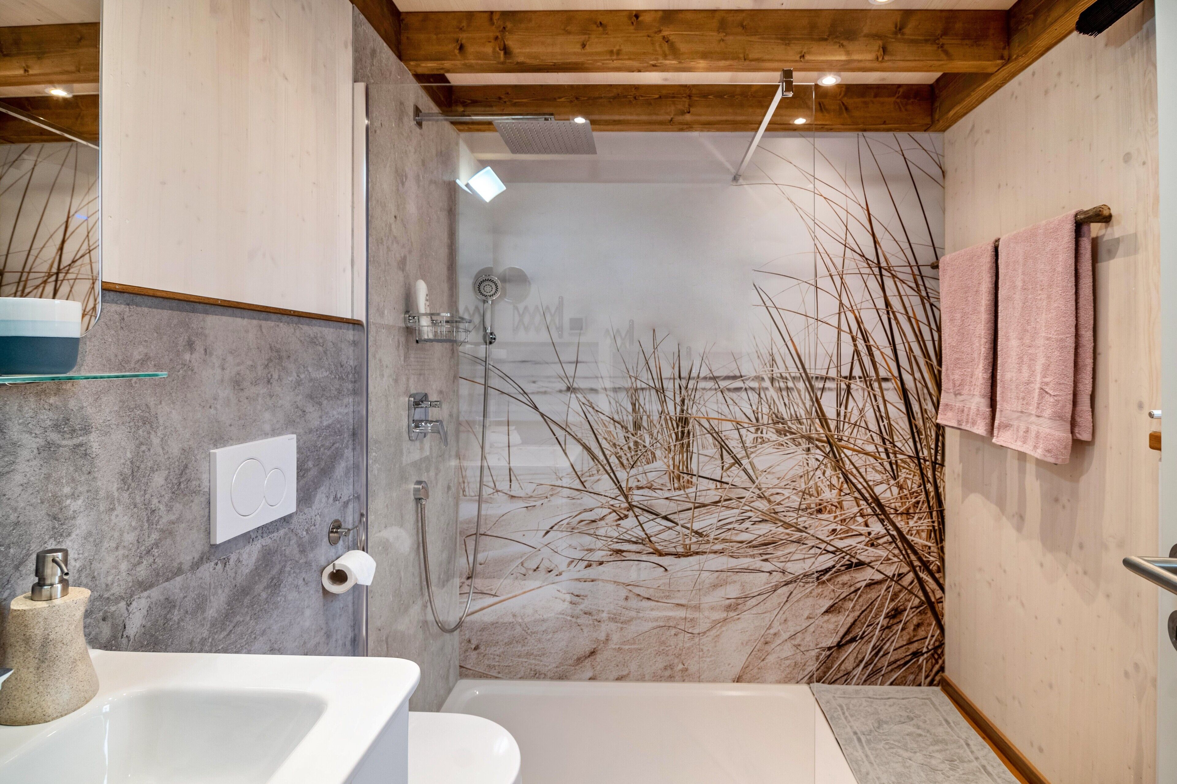 A modern bathroom with a shower, a sink, and a toilet.