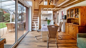 Una cocina amplia con armarios de madera y un comedor con sillas de mimbre.