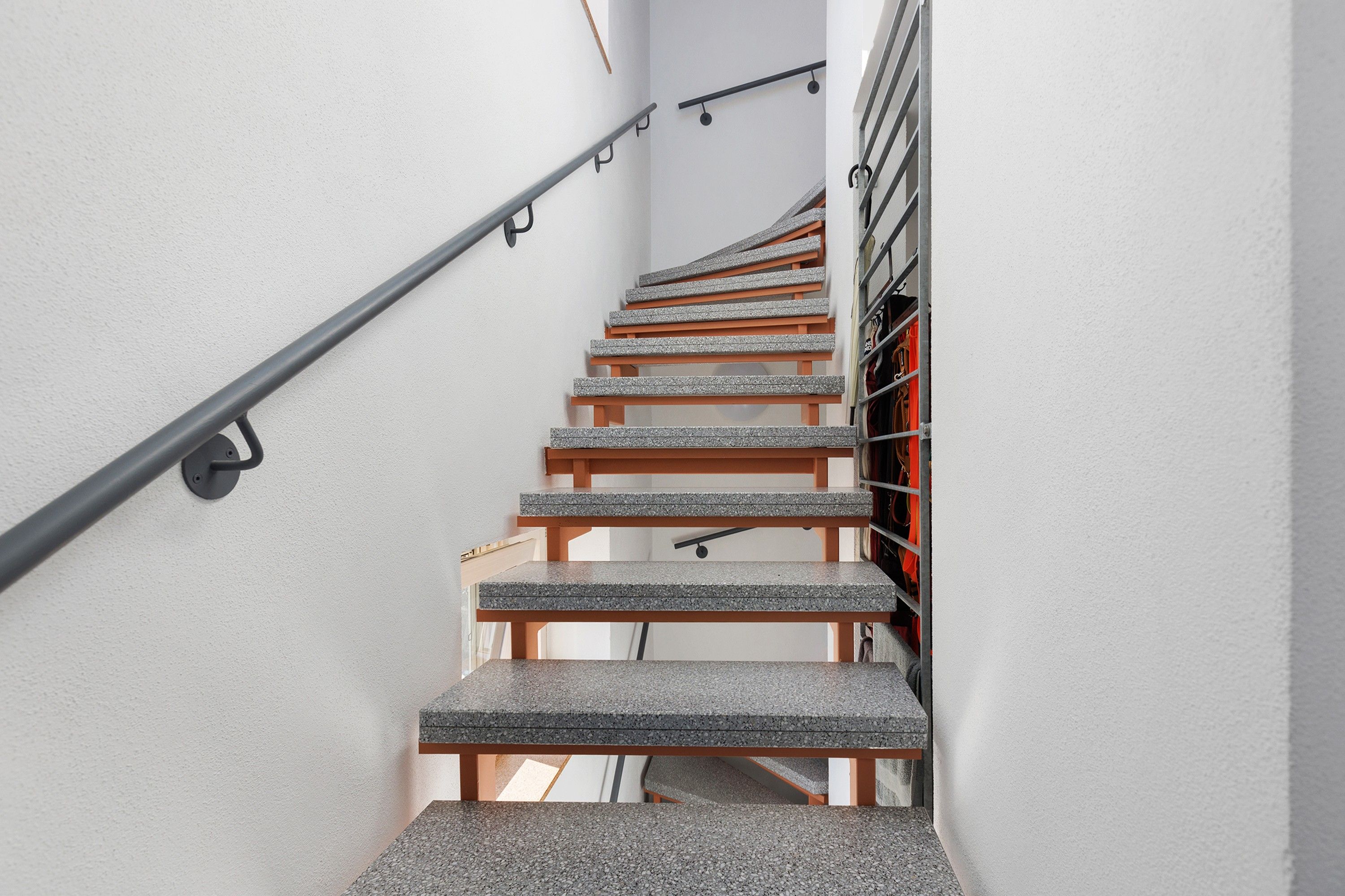 Eine Treppe mit Metallgeländer und Holzhäuschen.