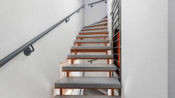 Eine Treppe mit Metallgeländer und Holzhäuschen.