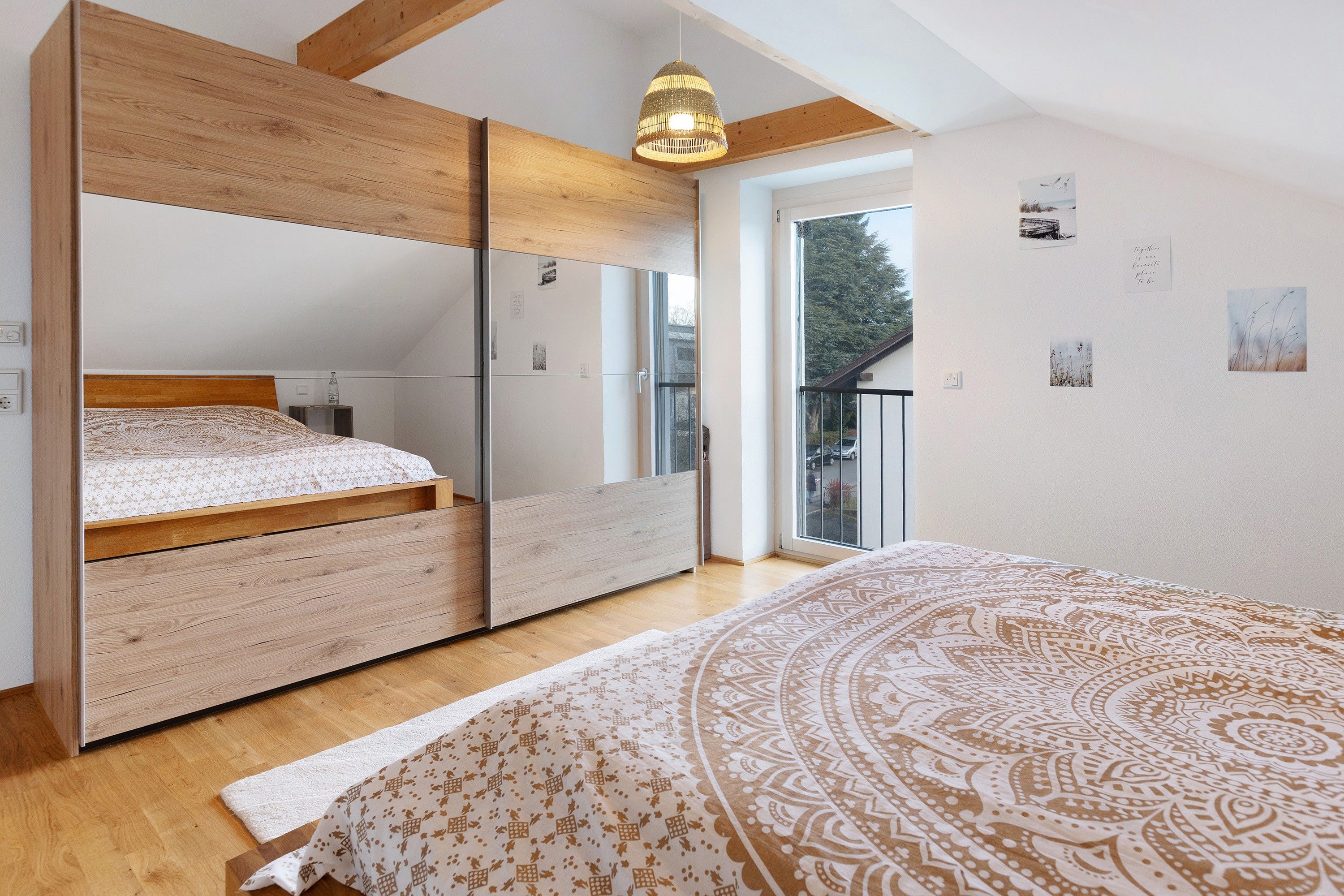 Ein Schlafzimmer mit einem Bett, einem Kleiderschrank, einem kleinen Tisch und einem Fenster.