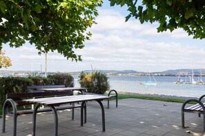 A waterfront park with benches and a view of boats on the water.