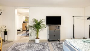 A bedroom with a bed, a TV, a plant, a desk, and a chair. - Apartment 'Gemütliche Unterkunft' with Private Terrace, Private Garden and Wi-Fi (Quickborn)