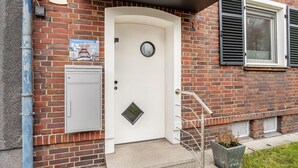 A brick building with a white door, a mailbox, and a number '167' sign. - Apartment 'Glückauf' with Wi-Fi (Castrop-Rauxel)