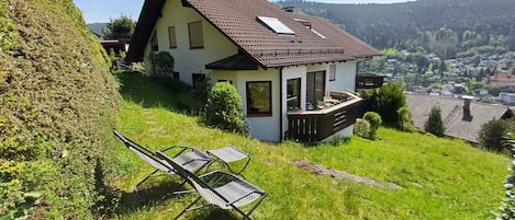 Una casa con techo inclinado, un balcón y vistas a un pueblo.