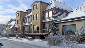 Ett hotell med flera våningar, balkonger och en snötäckt gata.