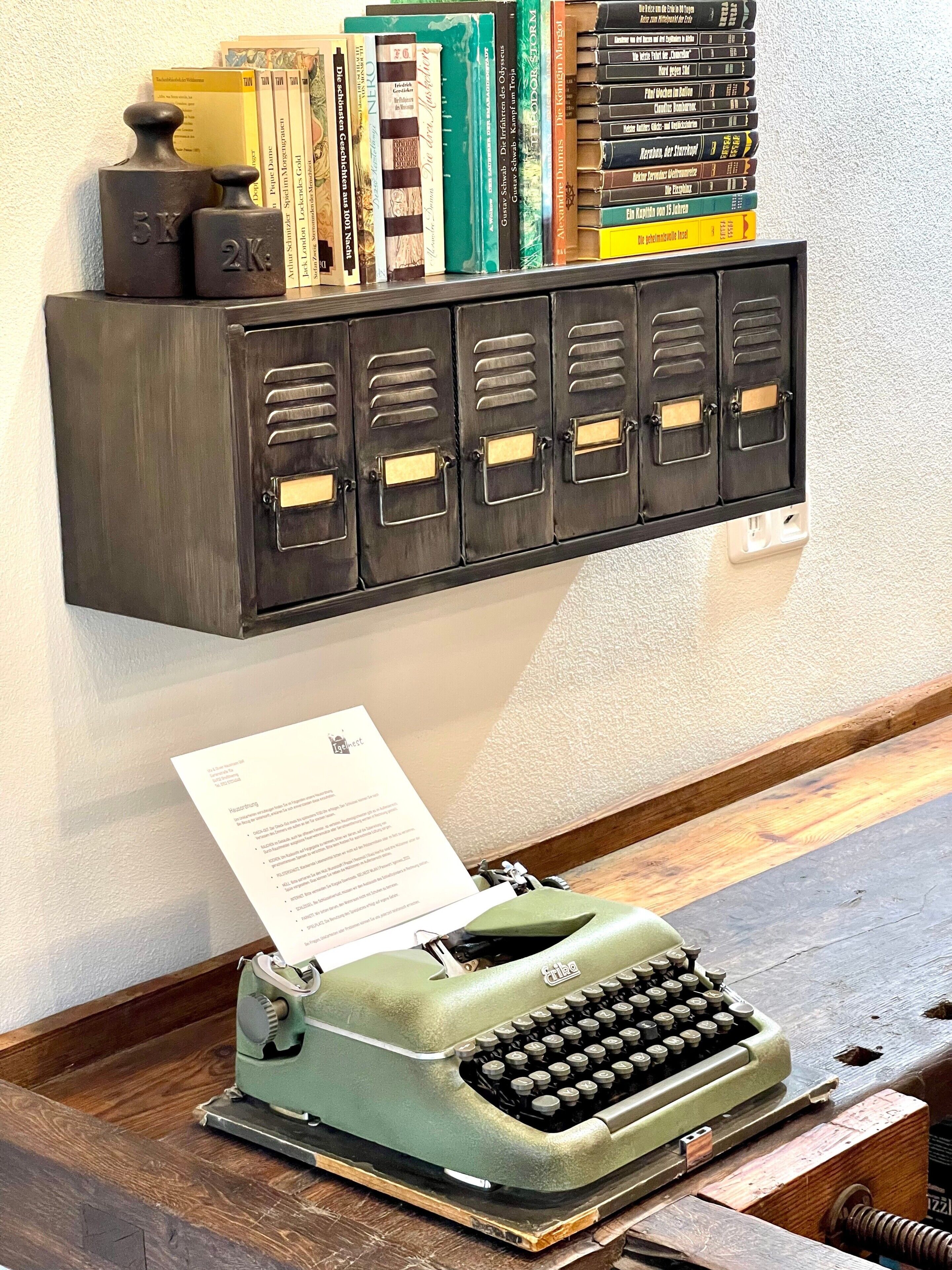 A vintage typewriter on a wooden desk with a paper in its slot.
