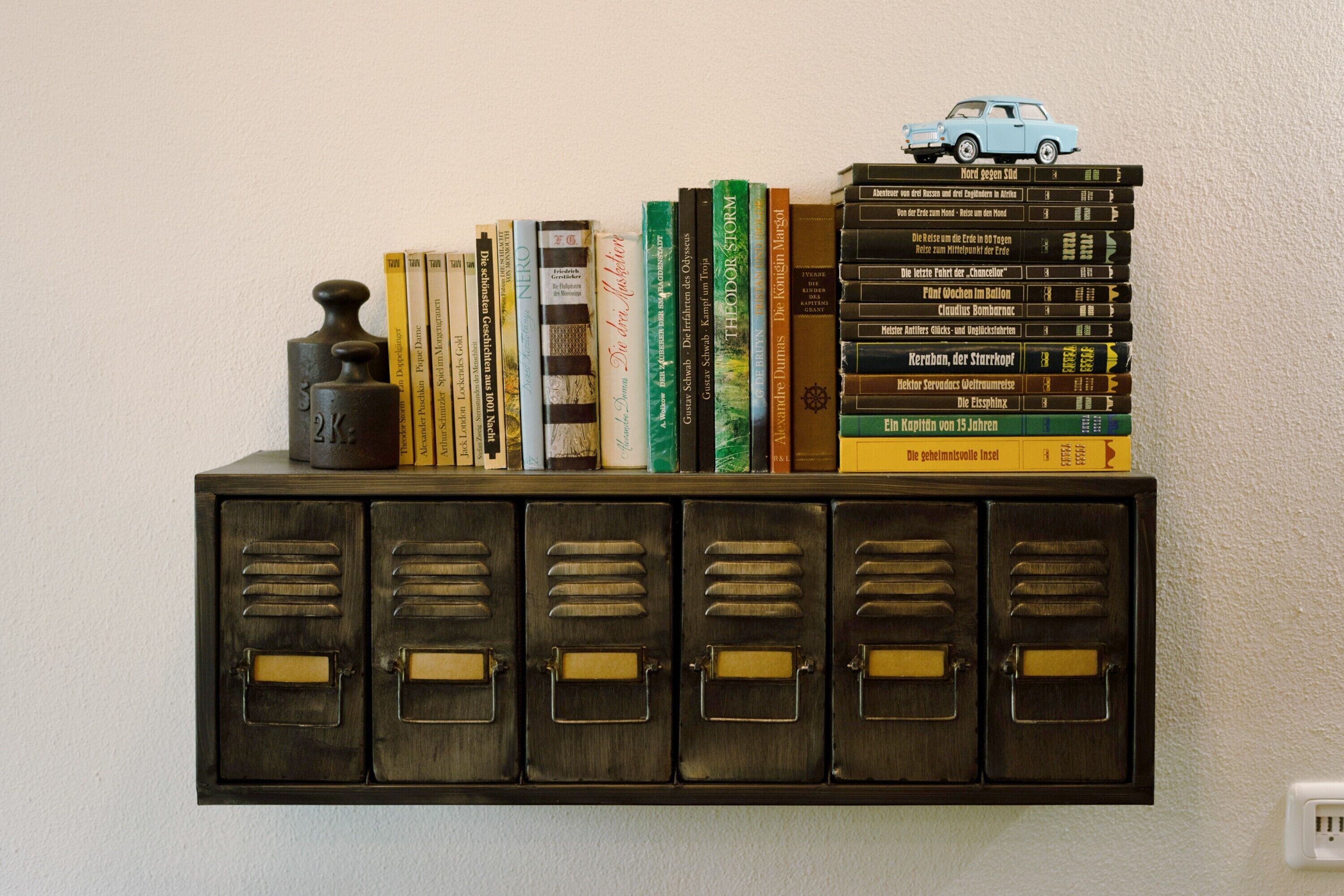 A bookshelf with books and a toy car.
