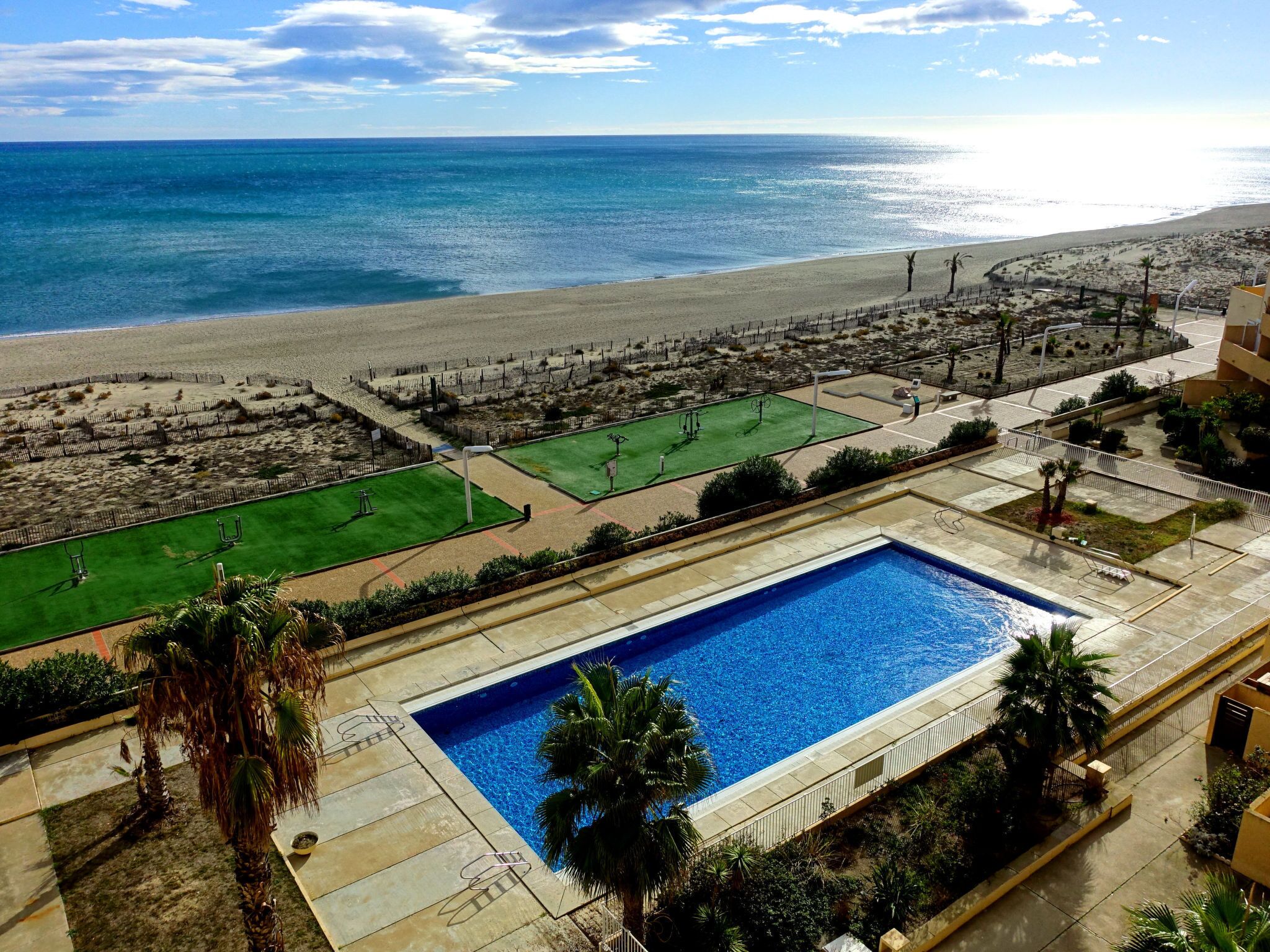 Ein Poolbereich mit Blick auf Strand und Meer.