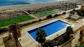 A pool area with a view of the beach and ocean.