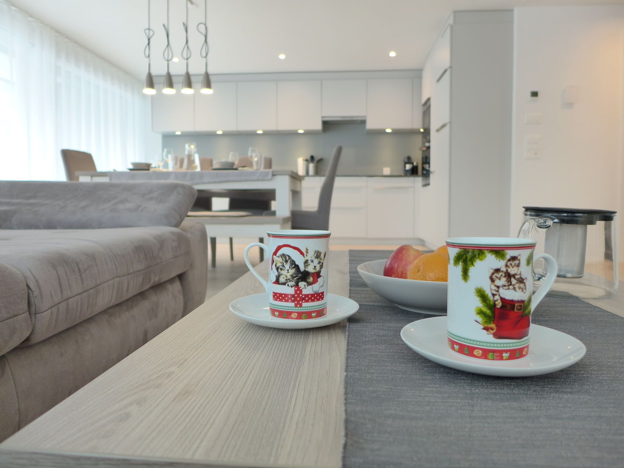 Un salon moderne avec un canapé, une table basse et deux tasses décoratives.