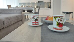 Un soggiorno moderno con un divano, un tavolino da caffè e due tazze decorative.