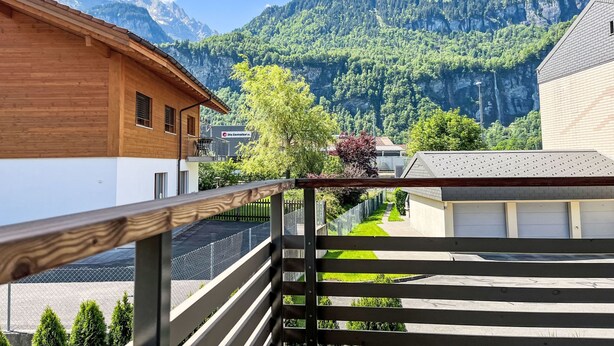 Un edificio in legno con un balcone che si affaccia su un paesaggio montano.