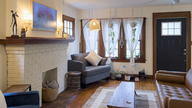Una sala de estar acogedora con chimenea, un sofá, una mesa de centro y una puerta.
