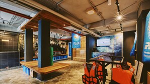 Um espaço interior moderno com um banco de madeira, exposição de coletes salva-vidas e uma tela grande.